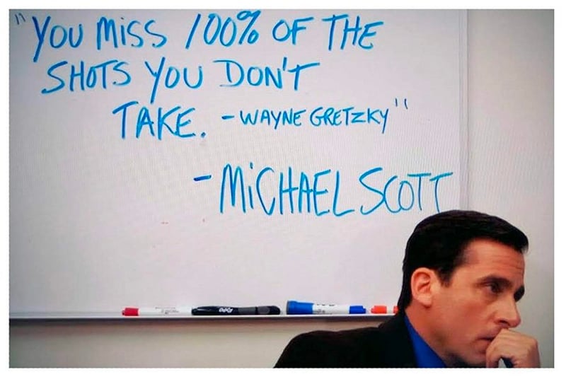 Michael Scott in front of a whiteboard with the quote "You miss 100% of the shots you don't take - Wayne Gretsky" written on it